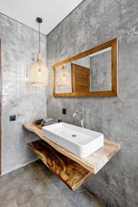 bagno con lavandino bianco e specchio di Elba Villa by Hombali a Canggu