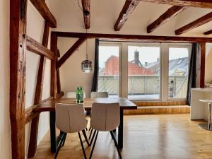 comedor con mesa y sillas y ventana grande en LudwigsHome: Zentralste Lage, SmartTV, Terrasse en Ludwigsburg