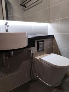SRITEL BOUTIQUE HOTEL في شاه عالم: حمام به مرحاض أبيض ومغسلة