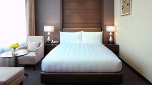 una camera d'albergo con letto e sedia di LOTTE City Hotel Gimpo Airport a Seul