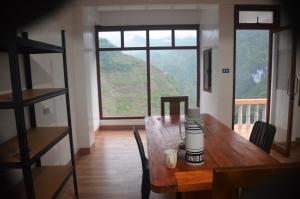 a dining room with a wooden table and a large window at Batad Roberto's Abung Inn and Restaurant in Banaue +47 photos