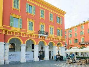 a large red building with yellow and white columns at Place Massena 4Pers Hyper Center AC in Nice