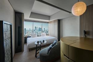 a hotel room with a bed and a table and a couch at The Royal Park Hotel Iconic Nagoya in Nagoya