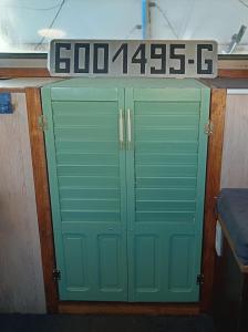 un par de puertas verdes de garaje en un barco en Le logement du marinier en Eckwersheim