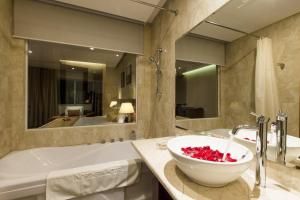 een badkamer met een bad en een kom op een aanrecht bij Stay Hotel in Da Nang