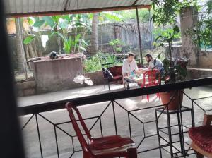 two men sitting at a table in a room with chairs at KENSON HOMESTAY in Mangalore