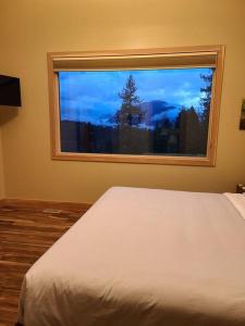 a bed in a bedroom with a window with a view at Five Star-Amazing views and Hot Tub in Crescent Valley