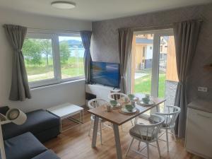 uma sala de estar com uma mesa e uma televisão em Apartmány - Malé Lipno em Černá v Pošumaví