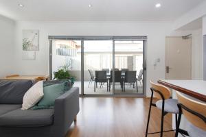 a living room with a couch and a table with chairs at Suburban Living - 2 bedroom apartment Victoria Park in Perth