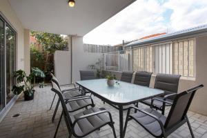 a patio with a table and chairs on a balcony at Suburban Living - 2 bedroom apartment Victoria Park in Perth