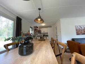 un jarrón con flores en una mesa de madera en la sala de estar en Luxe familiewoning Veluwe/Garderen / Rolstoelgeschikt, en Garderen