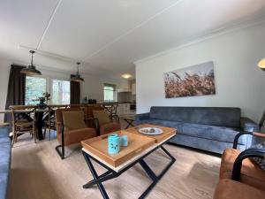 Una sala de estar con un sofá azul y una mesa. en Luxe familiewoning Veluwe/Garderen / Rolstoelgeschikt, en Garderen
