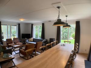 Una sala de estar con una gran mesa y sillas de madera. en Luxe familiewoning Veluwe/Garderen / Rolstoelgeschikt, en Garderen