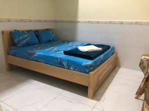 un letto con lenzuola blu e cuscini blu sopra di Nhà Nghỉ Bảo Ngọc a Tché Réou