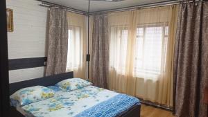 1 dormitorio con 1 cama y una ventana con cortinas en Відпочинок у Євгена та Оксани, en Yaremche
