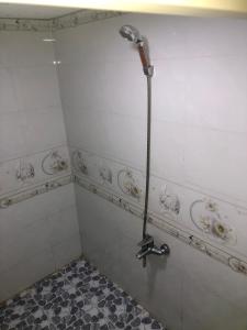 e bagno con doccia e parete piastrellata. di Nhà Nghỉ Bảo Ngọc a Tché Réou