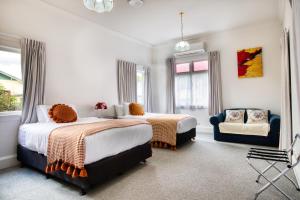 a bedroom with two beds and a chair at Villa near CBD and Globox Arena in Hamilton
