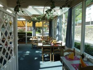a dining room with tables and chairs and windows at Hotel Sternen in Sisikon