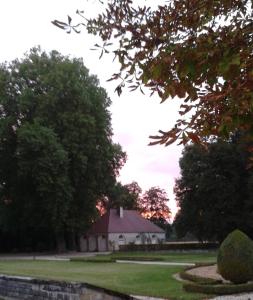 een witte kerk in het midden van een veld met bomen bij Le Château de BRESSEY & son Orangerie in Bressey-sur-Tille