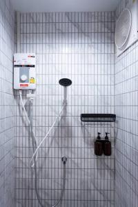 a shower in a white tiled bathroom with a shower at A2 Comfortable space wt Kitchen in Bangkok