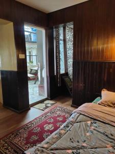 - une chambre avec un lit et une porte donnant sur une terrasse dans l'établissement Azalea Holidays On Mall, à Darjeeling