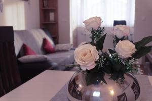 a vase filled with white roses on a table at Apartmani Jastreb in Jastrebarsko