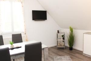 a living room with a table and a tv on the wall at Ferienwohnung Zum Gerdautal in Böddenstedt