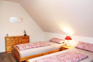 a bedroom with two beds and a dresser at Ferienwohnung Zum Gerdautal in Böddenstedt