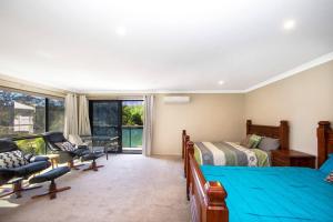 TuggerahEasygoing Poolside Relaxation on Wyong River的有两张床和一张书桌的卧室