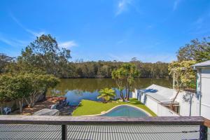 a house with a view of a lake at Easygoing Poolside Relaxation on Wyong River in Tuggerah