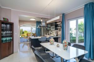 een keuken en eetkamer met een witte tafel en stoelen bij Villa Laperosa in Cavtat