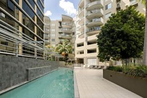 een zwembad op de binnenplaats van een appartementencomplex bij 'The Cordelia' Sweeping South Brisbane Style in Brisbane