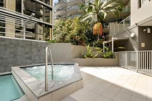 a hot tub in a courtyard next to a building at 'The Cordelia' Sweeping South Brisbane Style in Brisbane