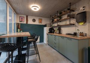 萊茵菲爾登的住宿－Ambrosia Hüsli，厨房配有柜台和一些凳子