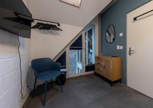 萊茵菲爾登的住宿－Ambrosia Hüsli，一间设有蓝色椅子和窗户的客房