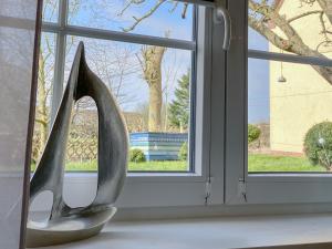 a sculpture of a pair of high heels in front of a window at Appartement Huus Appelboom in Nordstrand