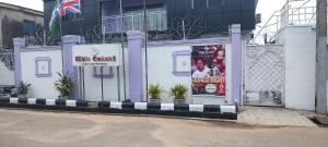 a building with a sign on the side of it at WHITE EMIRATES HOTEL AND APARTMENT in Akinde