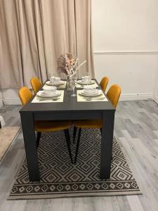 a black table with chairs and a vase of flowers at Cedar Lodge in Walton on the Hill