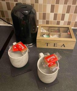 a table with two bowls and a box of tea at Cedar Lodge in Walton on the Hill