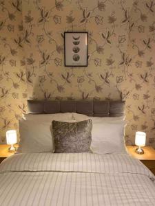 a bedroom with a bed with two lamps on both sides at Cedar Lodge in Walton on the Hill