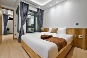 um quarto com uma cama grande e um cobertor castanho. em The Galaxy Home Doi Can Hotel and Apartment em Hanói