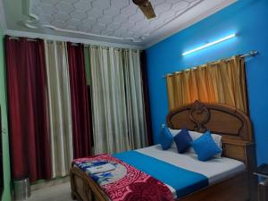 a bedroom with a bed with blue walls and curtains at Hotel Holiday Classic in Chandīgarh