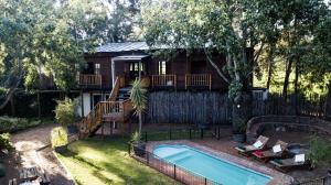 a backyard with a pool and a house at Vindoux Tree House Guest Farm & Spa in Tulbagh
