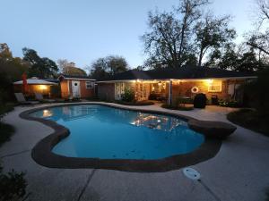 a swimming pool in a yard with a house at Exquisite 3x2 W Pool Oasis Near City Center in Houston