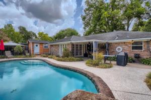 a home with a swimming pool in front of a house at Exquisite 3x2 W Pool Oasis Near City Center in Houston