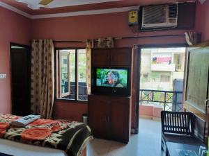 Schlafzimmer mit einem TV, einem Bett und einem Fenster in der Unterkunft Hotel Holiday Classic in Chandīgarh