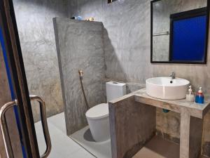 a bathroom with a sink and a toilet and a mirror at Lanta Happy House in Ko Lanta