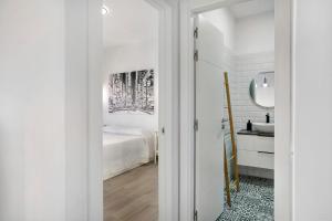 een witte slaapkamer met een bed en een wastafel bij Apartamento Kalma in Las Eras