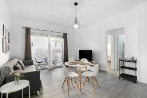 een woonkamer met een bank en een tafel en stoelen bij Apartamento Kalma in Las Eras