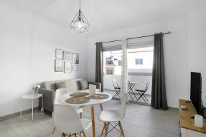 a white living room with a table and chairs at Apartamento Kalma in Las Eras
